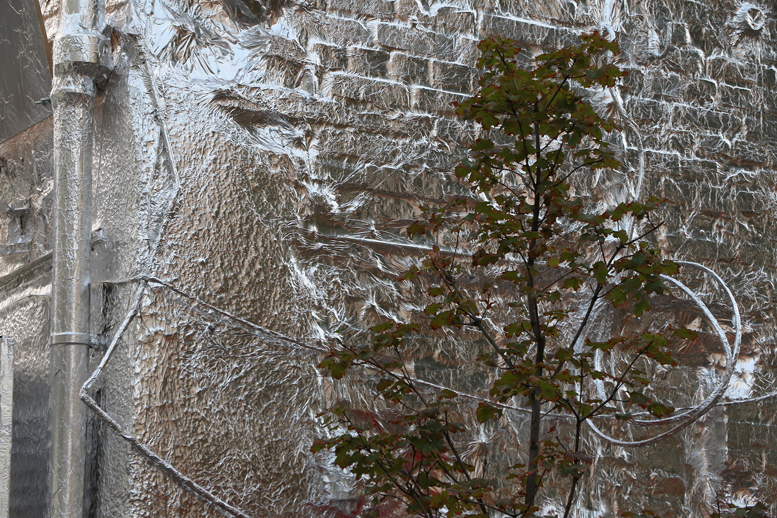 Polish artist Piotr Janowski wraps a Warsaw building in tin foil