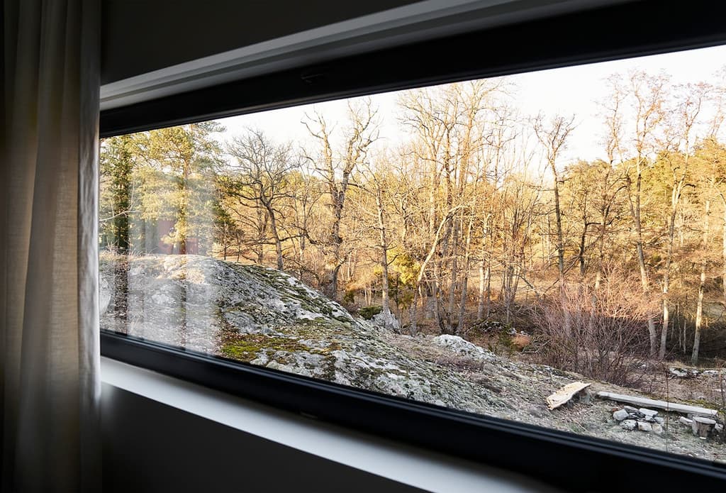A minimalist Swedish home floats above a rocky outcrop in Värmdö