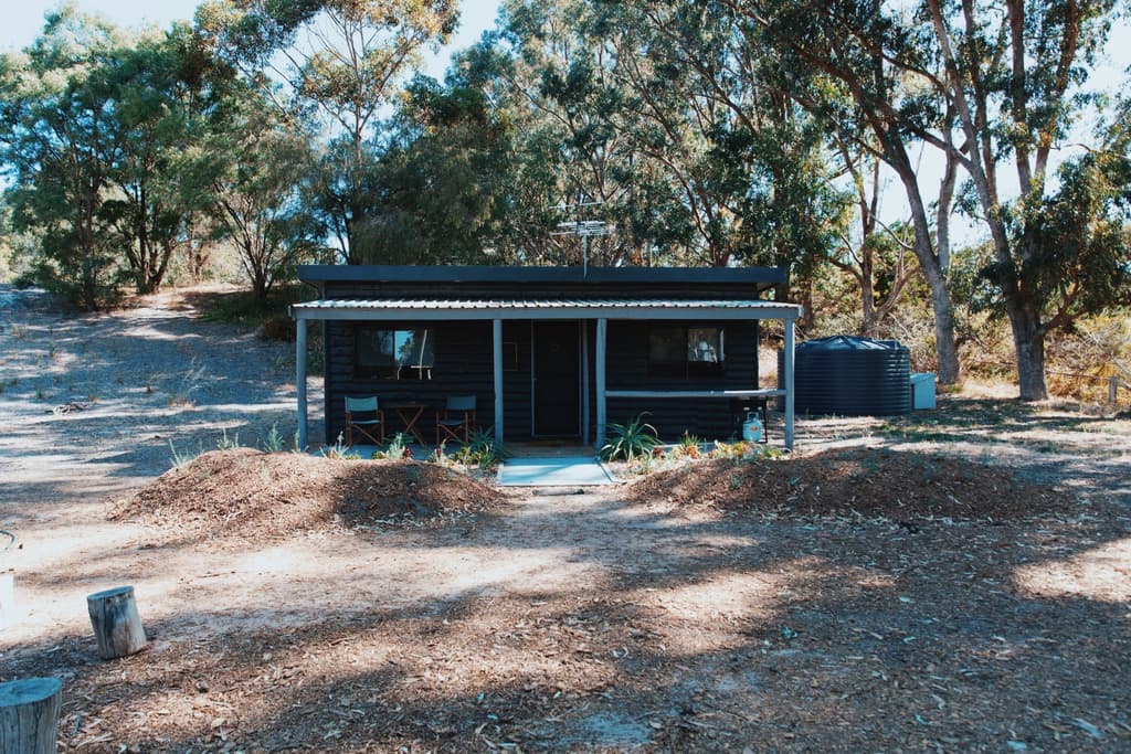 Log cabins nestle behind the sand dunes in Western Australia