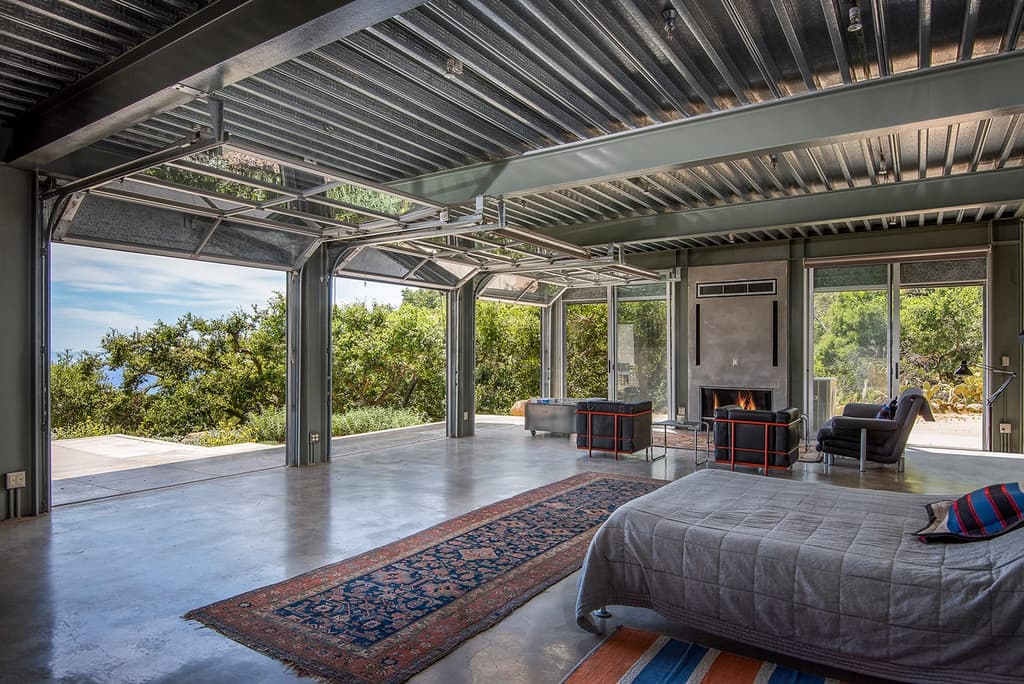 Concrete floors, steel beams, corrugated ceilings and rolling steel-framed doors feature inside the industrial style Barton Myers Residence, for sale in Santa Barbara via Sotheby's International