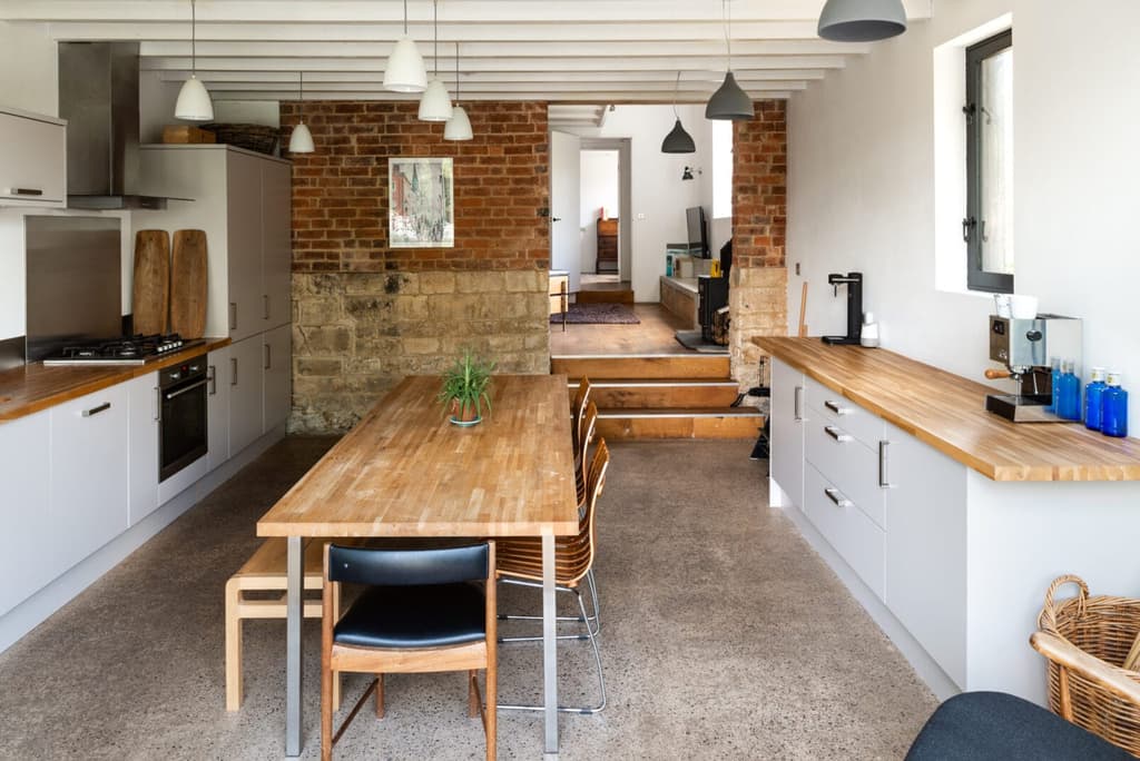 Industrial features inspire contemporary interventions, such as wide oak floorboards, handmade cabinetry and cast concrete shelving.