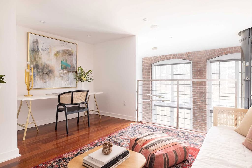 A mezzanine-level den with double height arched windows