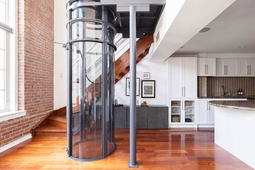 The apartment is serviced by a glass-enclosed elevator