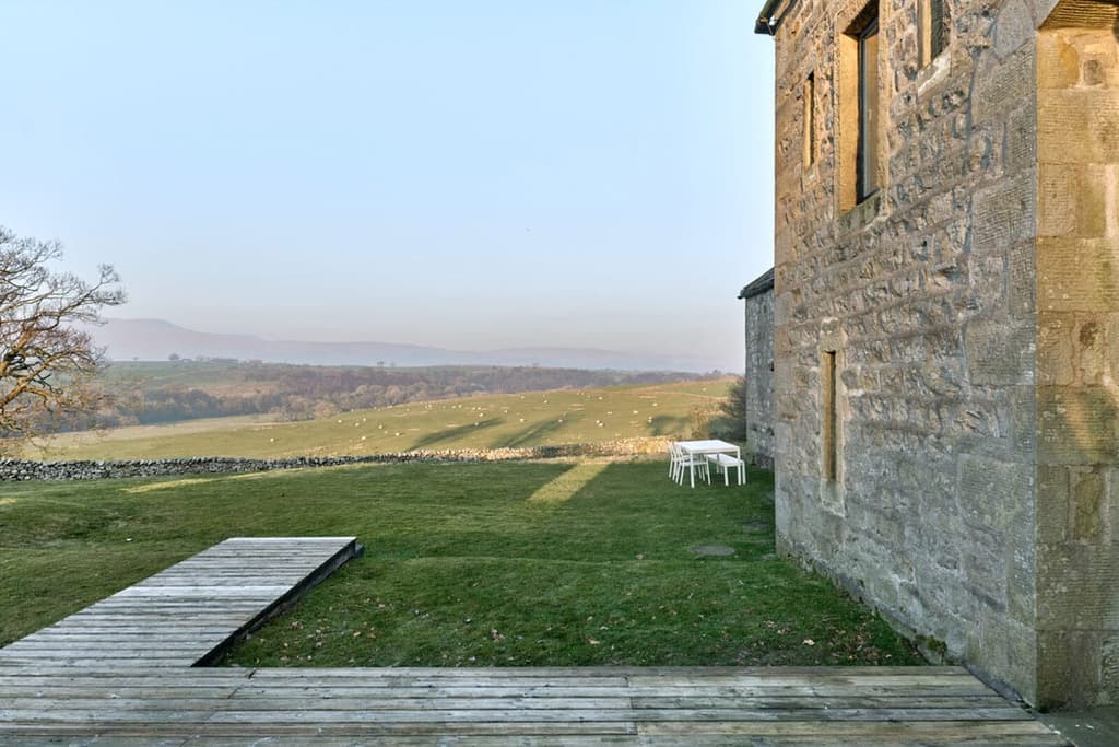 Large picture windows puncture the barn’s historic gritstone facade, and skylights have been added on the simple slate roof to amplify light inside the five-bedroom country property.