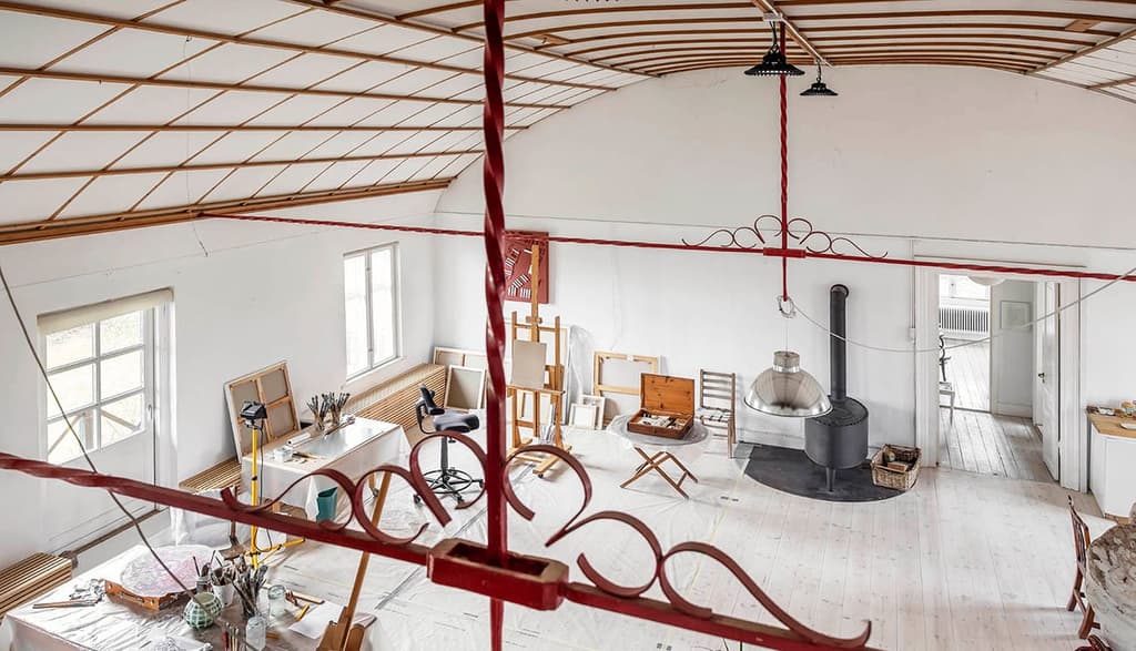 A view across the studio space from the upper balcony level. Note the detailing on the barrel ceiling and its ornate metal work