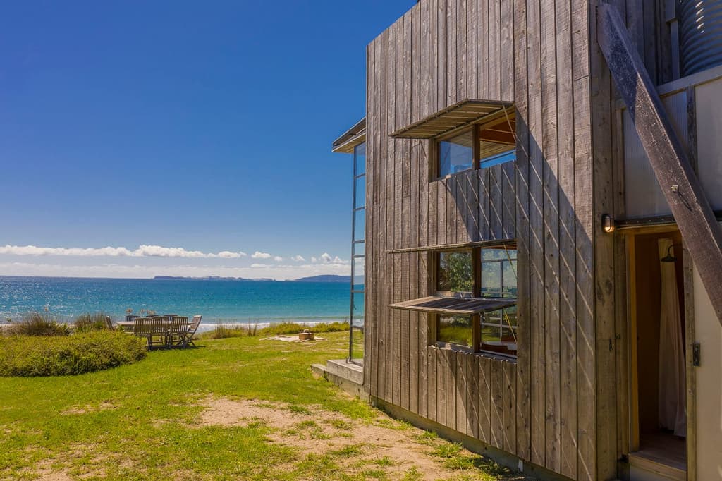 This award-winning New Zealand coastal cabin has been built on wooden runners, limiting impact on its natural environment while enabling it to be easily towed away