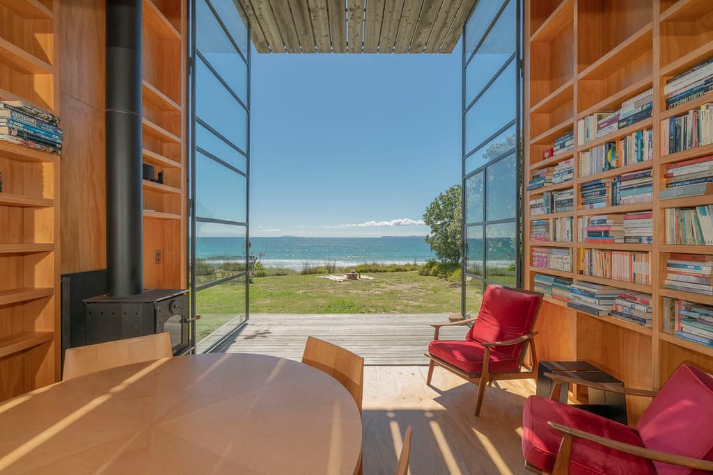 This award-winning New Zealand coastal cabin has been built on wooden runners, limiting impact on its natural environment while enabling it to be easily towed away