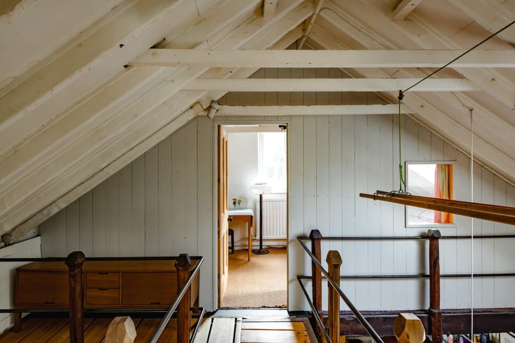 A view through the upper level of the London property, where bedrooms are set beneath the a-frame trusses and eaves of the pitched roof
