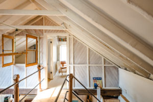 An open walkway connects the bedroom 'haylofts' in the space. It has metal railings and a staircase commissioned bespoke by a specialist metalworker