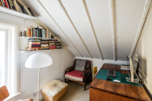 There's a small study set beneath the eaves for a convenient work-from-home set-up