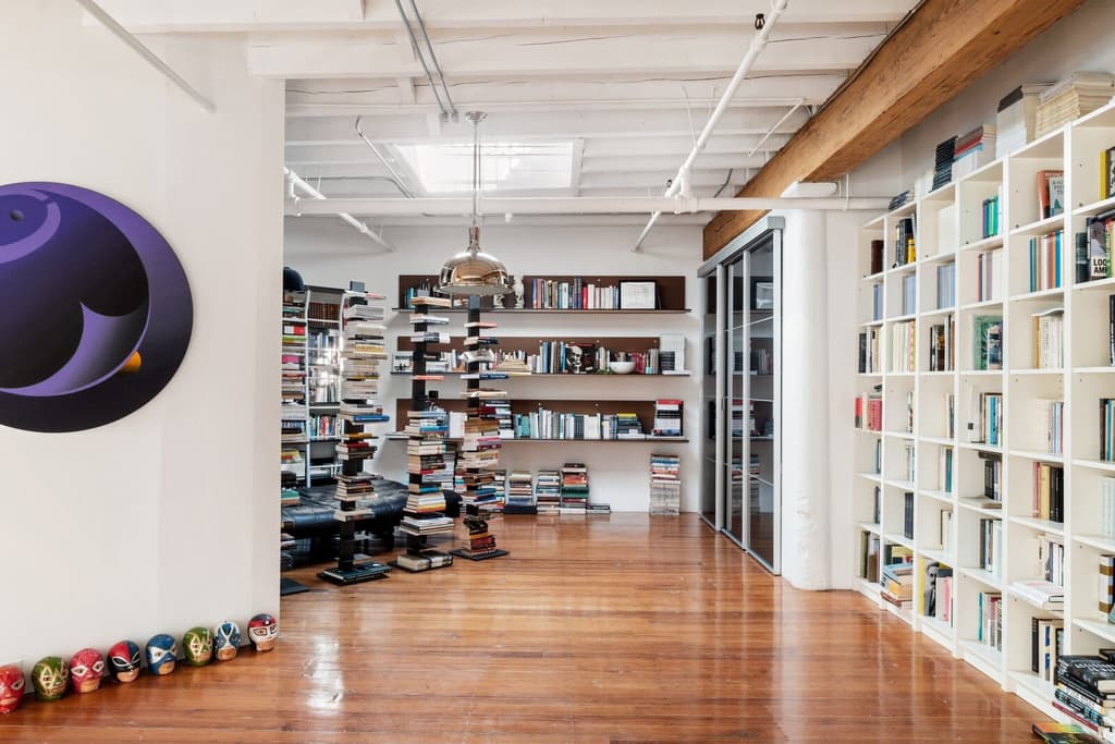 The library features floor-to-ceiling built in shelving and has a skylight roof