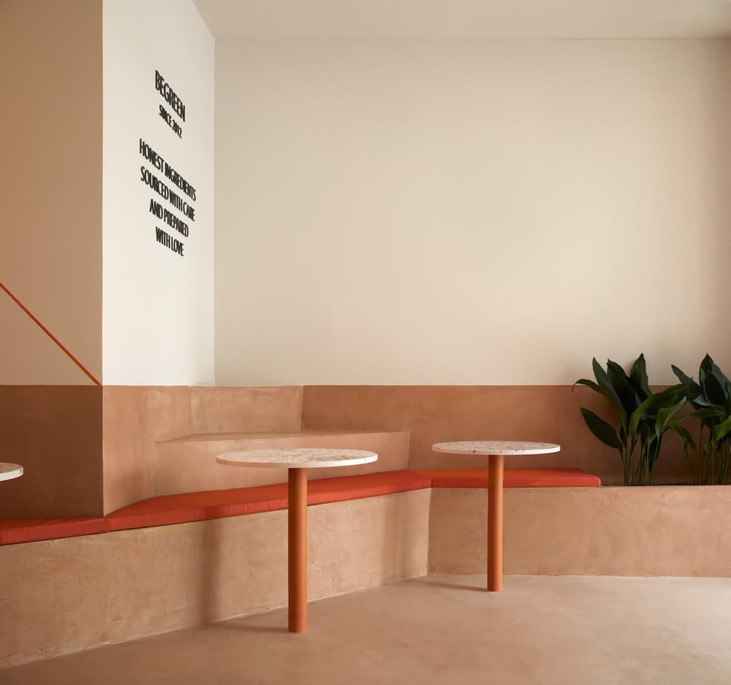 Terrazzo topped tables and cushioned corner seats run along the length of a raised section in the restaurant – installed by designers Horma Studio to make the most of BeGood salad bar’s long, narrow floor plan.