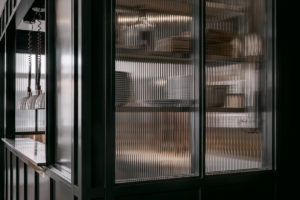 Fluted glass around the kitchen recalls the bank manager's office