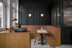 Terracotta banquettes complement forest green walls