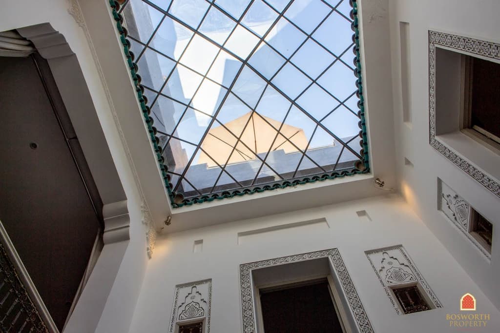 The large sun awning can be glimpsed from beneath the grass skylight that covers the courtyard