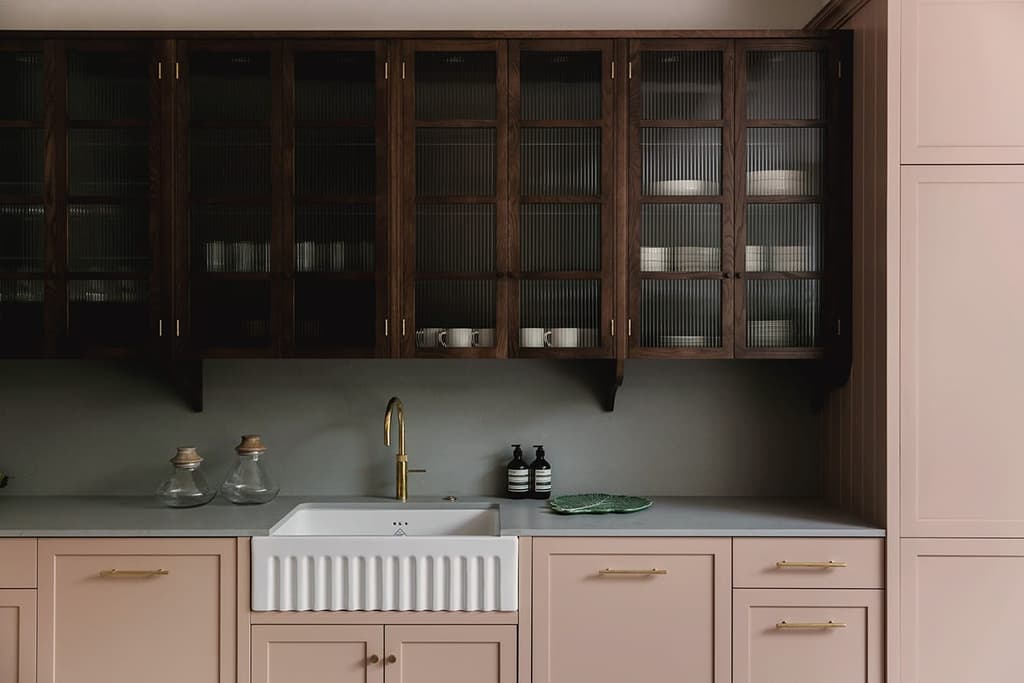 The soothing and serene interiors of Flower Lane's kitchen. Notice how the dark wooden cupboards juxtapose the contemporary dusty pink cabinets and cool green backsplash