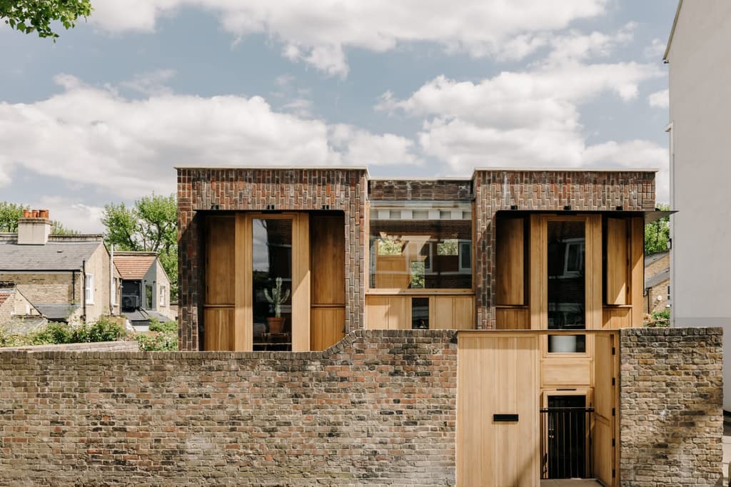 The house is concealed by a historic garden wall and takes over a former garage site