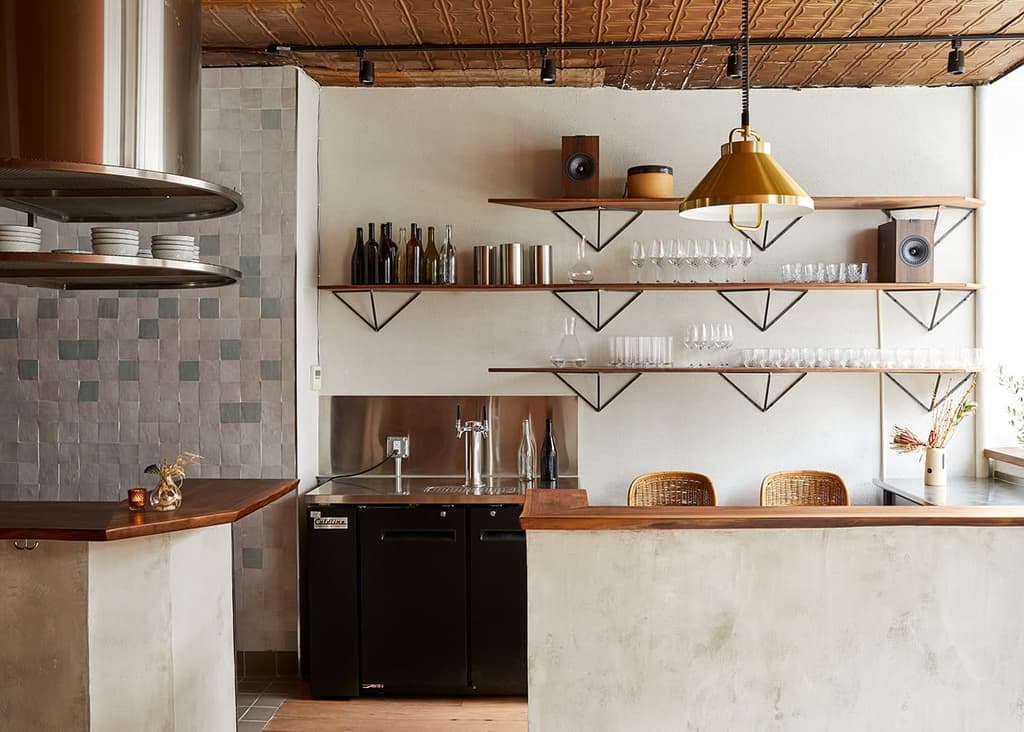 Simple interiors are grounded in location via tin plate ceilings and tiles by local studios