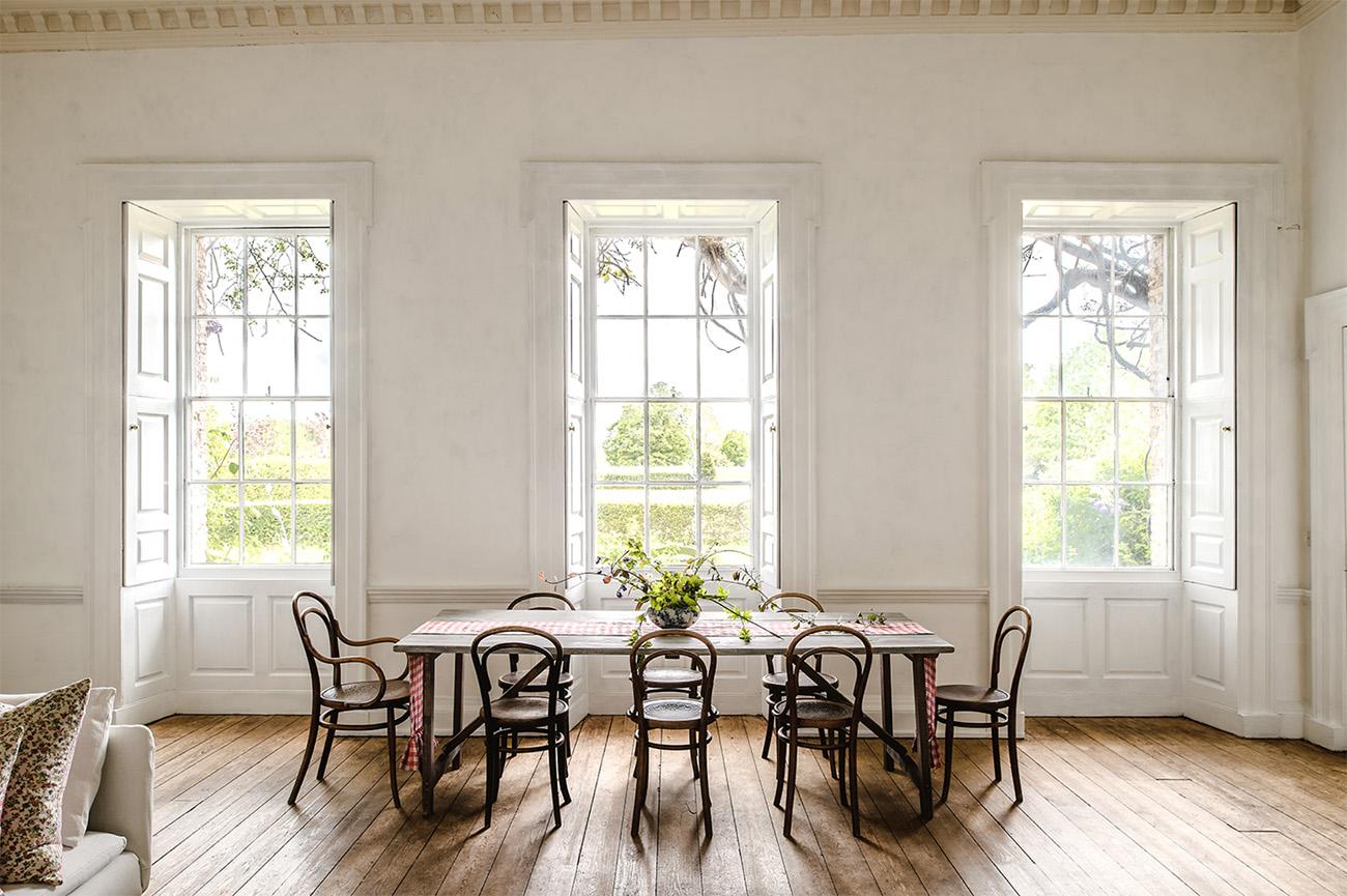 The dining room features triple aspect bay windows, rococo ceilings and stripped floorboards