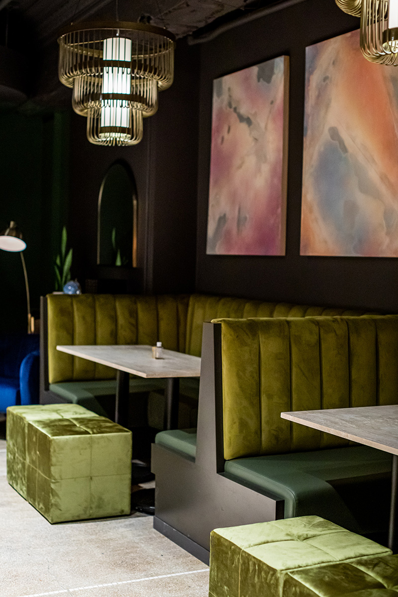 Mossy velveted banquettes and stools contrast the concrete, stone and metal of the Shelby's structure