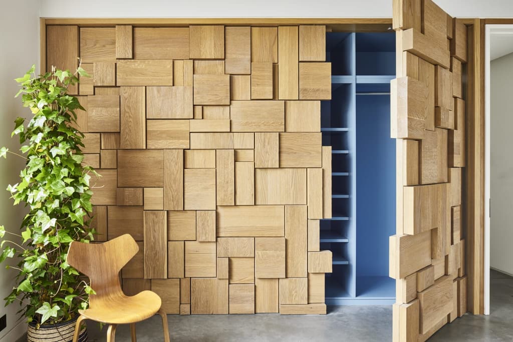 Jigsaw like oak panels reveal concealed wardrobes