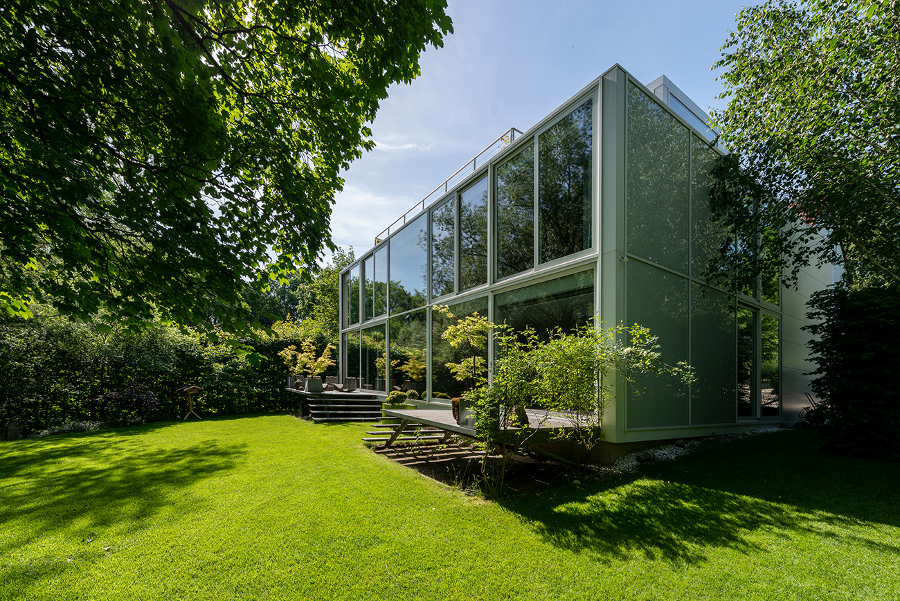 While the front of the building is windowless, at the rear, overlooking the garden, the entire back wall comprises glass panels