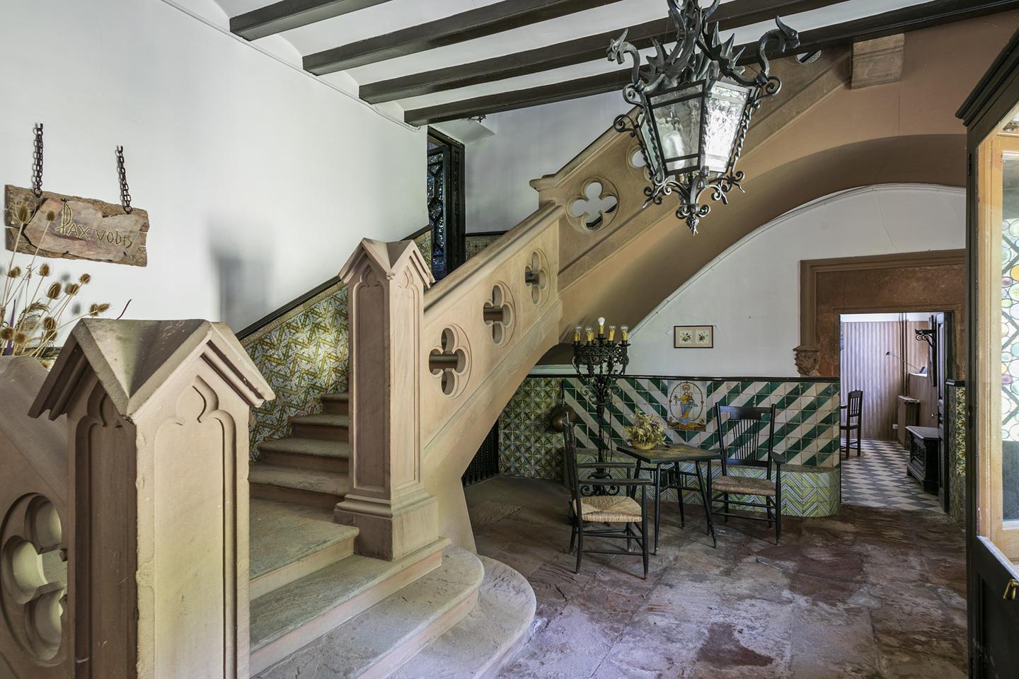 The grand hallway features a carved stone staircase, and an inscribed arch from 1635, while the roof features defensive turrets, which nod to its construction during a chaotic period of history