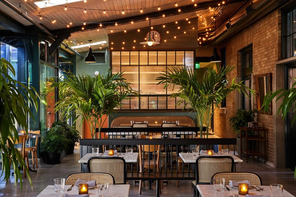 The old train platform is now an informal patio area with string lights and giant palms, and a decommissioned train carriage