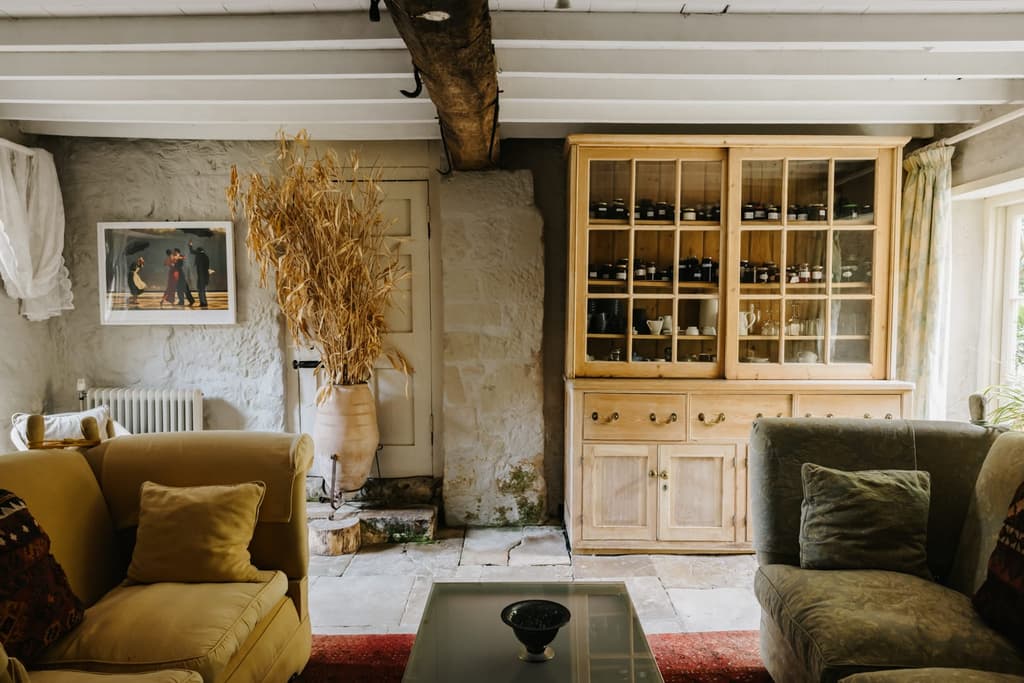 Stone floors and walls, rough hewn beams and raftered ceilings feature in the livingroom