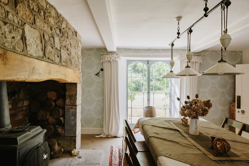 The dining room features french doors that open onto the lawns, as well as a large Inglenook fireplace with woodburning stove
