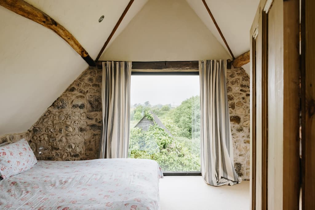 One of seven bedrooms with views across the wooded hillside
