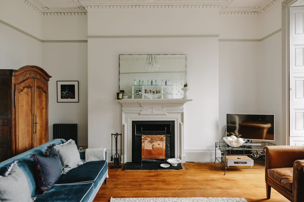 Restored plasterwork is the main ornamentation across its serene, chalk-coloured rooms, with patinated pine floorboards and fireplaces injecting warmth into the minimalist, lofty spaces.