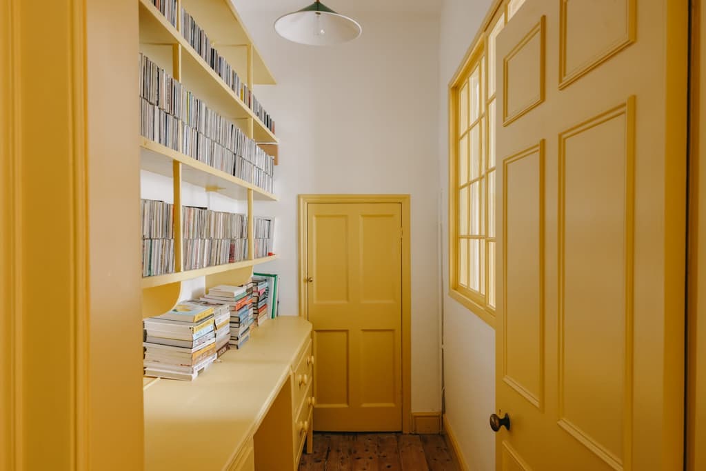 The kitchen has been modernised with veined marble countertops, while the pantry and dining room have cheerful yellow and green storage.