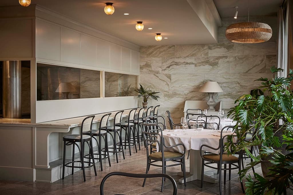 Tactile touches come via cane-backed furniture, simple white tableware, bamboo woven lighting pendants and marble wall cladding
