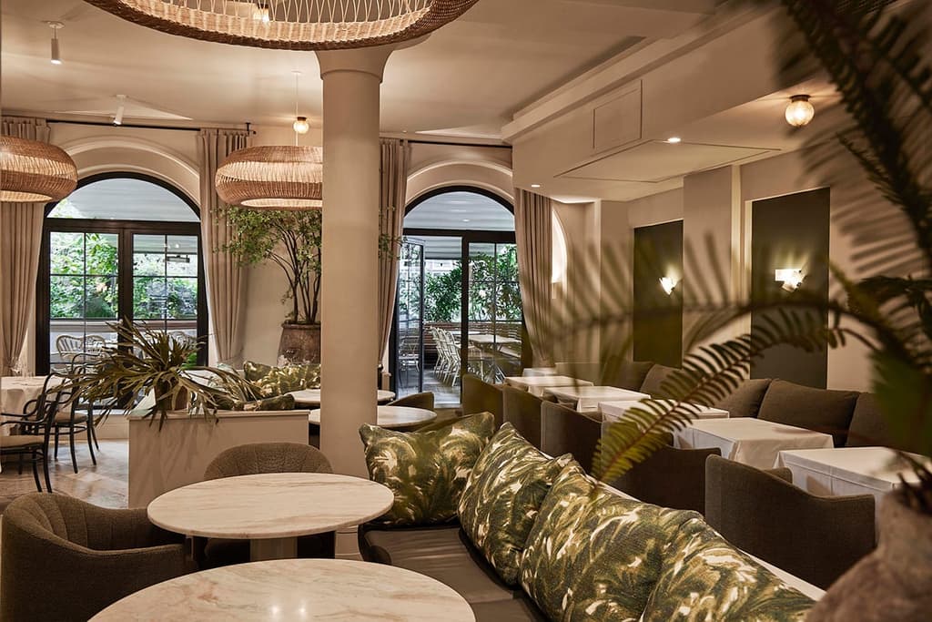 In the galley dining area, seating features botanically-themed upholstery and cushions, ferns and large-leaf evergreen plants