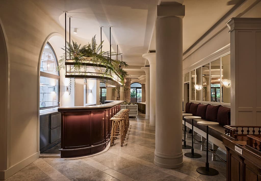 Staggered marble flooring, arched windows and concrete column are the main architectural features of the space