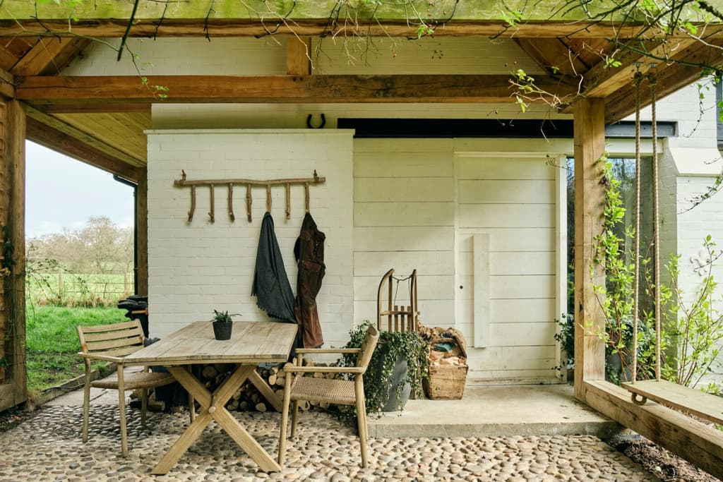 A shaded outdoor dining terrace – with views of the private gardens and fields beyond