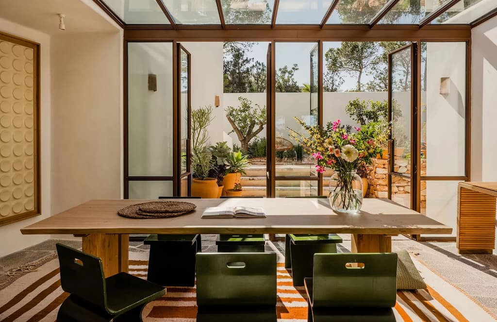 A new, woody villa overlooks a pebbly cove in Ibiza