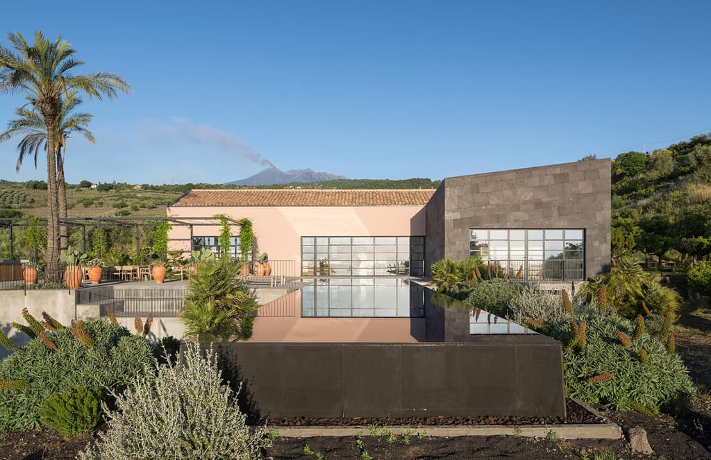 Volcanic stone and sand distinguish this L-shaped home on the Med