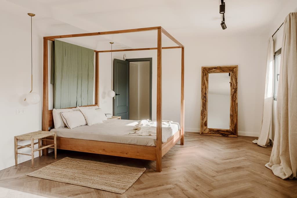One of the first floor bedrooms, complete with four poster bed, ensuite, herringbone floor and petrol blue door trims – restored from the original.