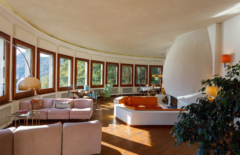The living room has a number of seating areas and 180 degree views of the lake and mountains.