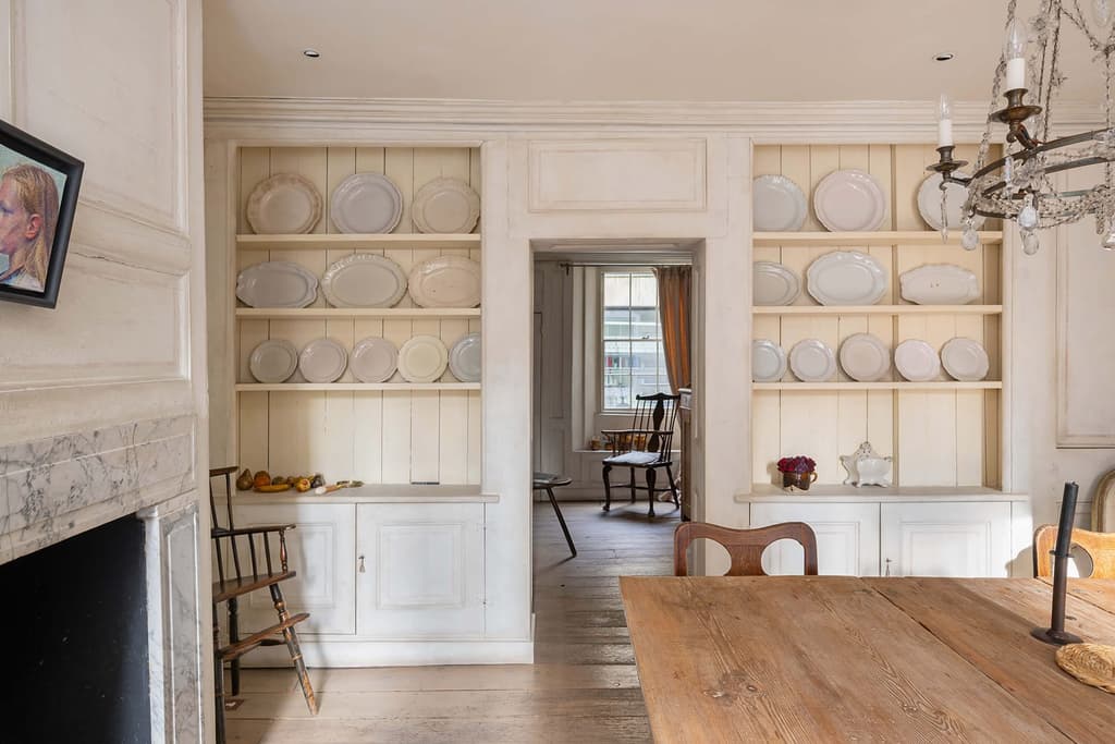The dining room – complete with blue-veined marble fireplace and weathered cabinetry decorated in the Gustavian style