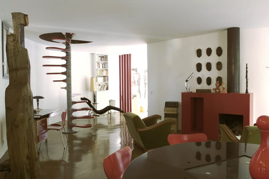 The main living space, with a skeletal spiral staircase and geometric fireplace