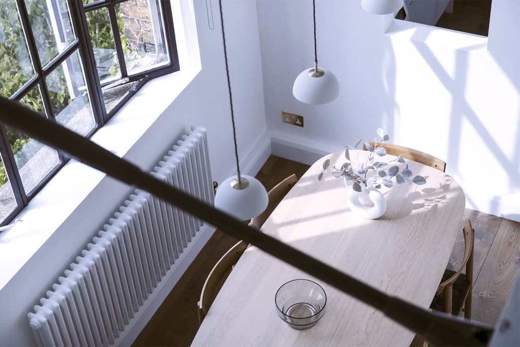 View of the dining room with hanging light pendants and black roof beams