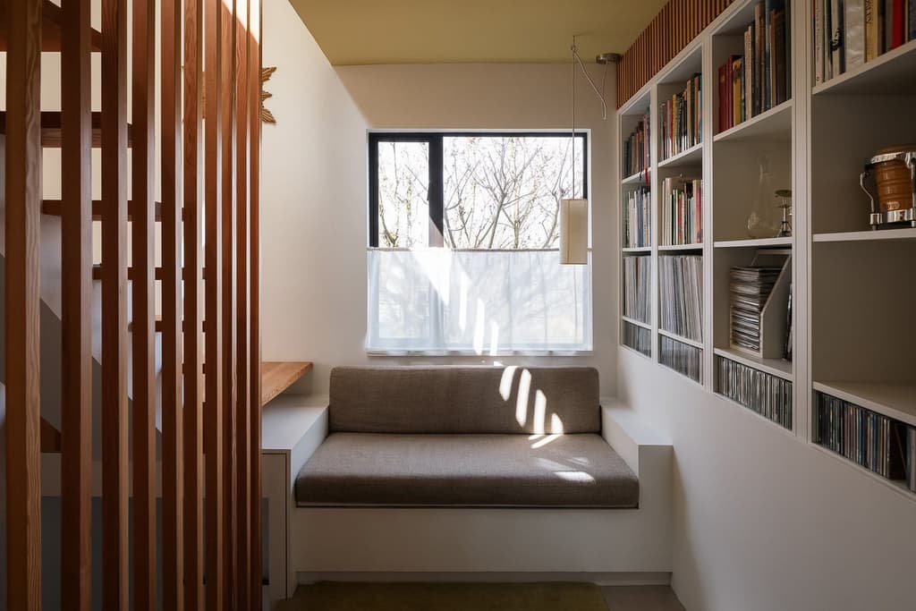 A quiet seating nook at the base of the stairs, with built-in bookshelves