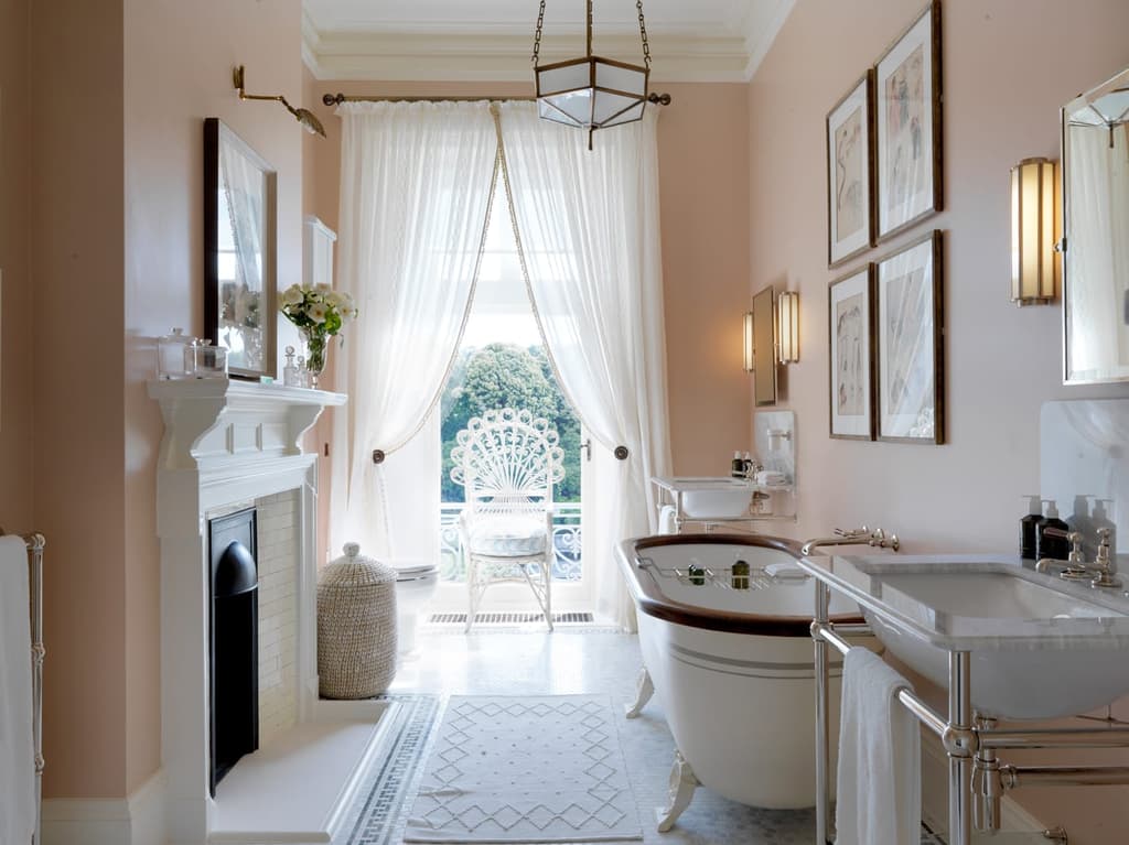 The bathroom of the Elizabeth Taylor Suite at Beaverbrook Hotel in the Surrey Hills makes use of sheer curtains to create milky light