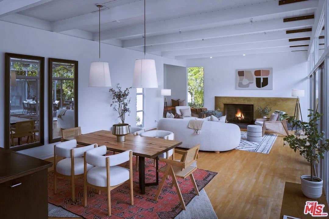 living room and dining area with beamed ceilings and maple floors
