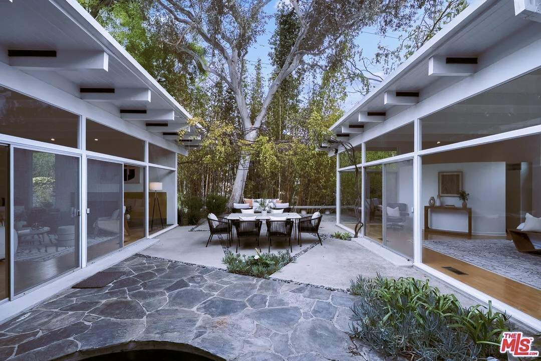 The house unravels around a central courtyard with a pond and fountain. Tall bamboo helps seclude the Brentwood property