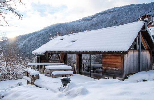 A restored alpine refuge overlooks Annecy from a wooded trailhead