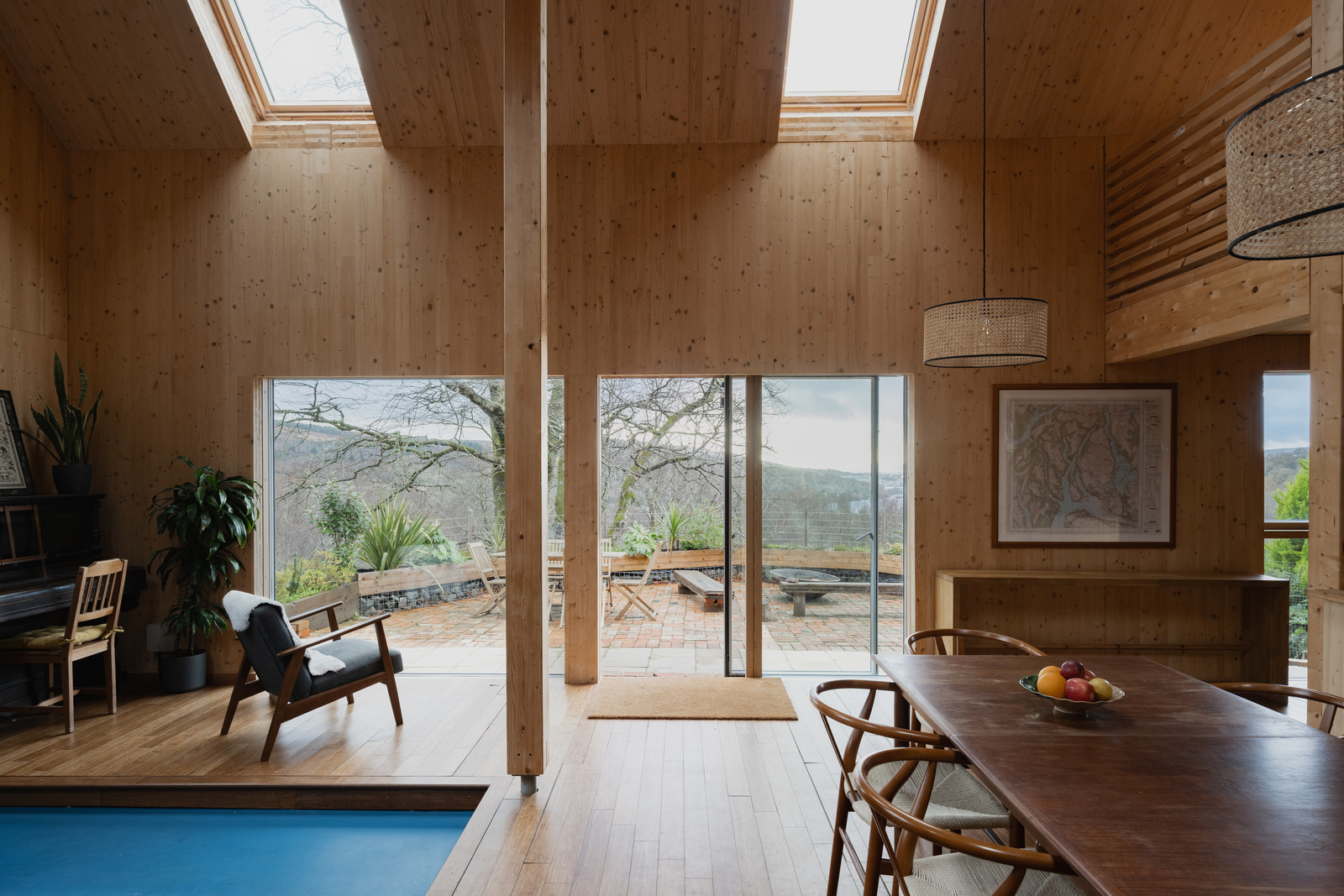 A contemporary timber longhouse perches above a Scottish loch